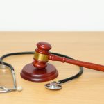 Gavel and stethoscope on table. Medical and Health Law, legal of medical malpractice concept